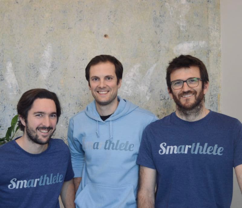 Das Team trägt blaue Firmenkleidung, auf der Vorderseite ist das horizontale Smarthlete-Logo zu sehen. Das Smarthlete Gründerteam, bestehend aus 3 Mitgründern.